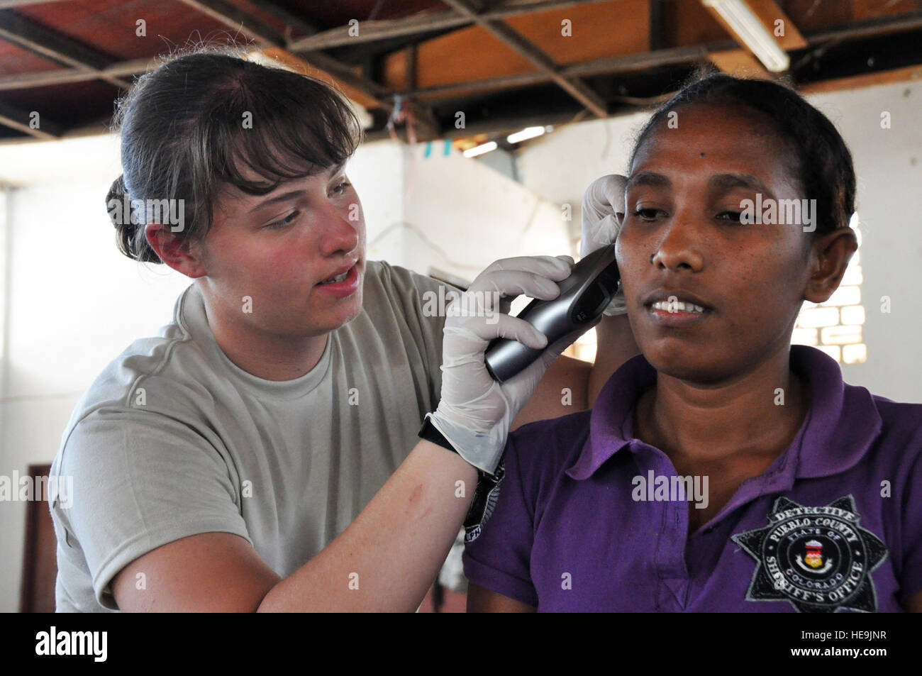 Airman Senior Ashley Cope procède à un examen de l'oreille sur une femme du Timor oriental au cours de procédures inprocessing dans une clinique le 16 juillet à Dili, Timor Leste. Airman Cope est affecté en tant que technicien en travail et de livraison au 3e Groupe médical à la base aérienne Elmendorf, en Alaska. Timorais et des responsables américains ont mis en place l'établissement dans le cadre de l'opération 2009, un ange du Pacifique Pacific Air Forces d'aide humanitaire menées par 13e armée de l'air à Hickam AFB, Washington. Tech. Le Sgt. Cohen A. Young) Banque D'Images