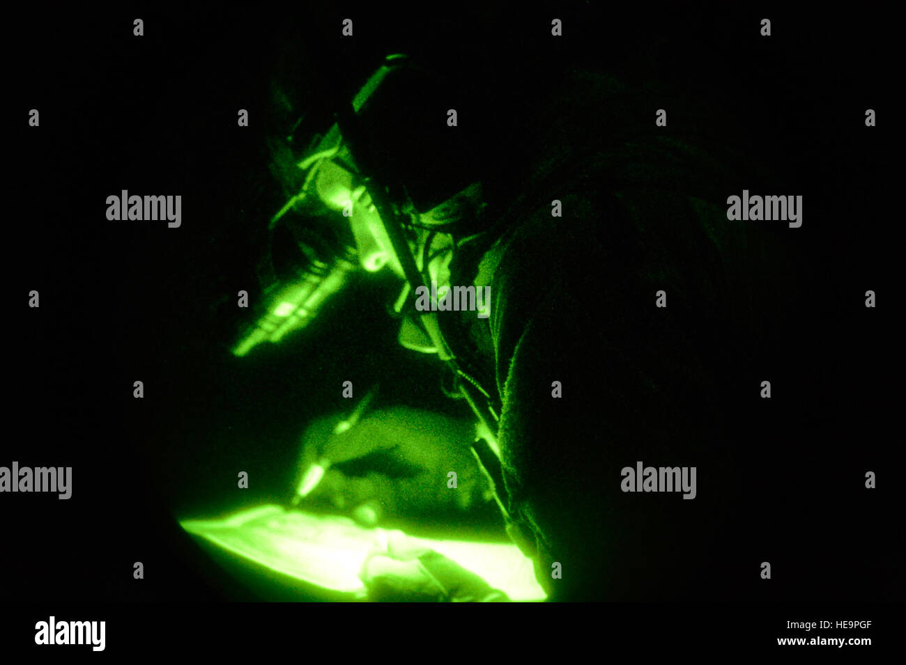 Un membre de l'US Air Force à partir de la 21e Special Tactics Squadron utilise sa vision nocturne pour tracer des points sur une carte Guerrier 2015 émeraude au cours de l'aéroport à Marianna, en Floride, le 29 avril 2015. Emerald Warrior est le ministère de la Défense que l'exercice de guerre irrégulière, permettant aux partenaires de conjointes et combinées pour former ensemble et se préparer à des opérations de contingence du monde réel. Keith James Senior Airman Banque D'Images