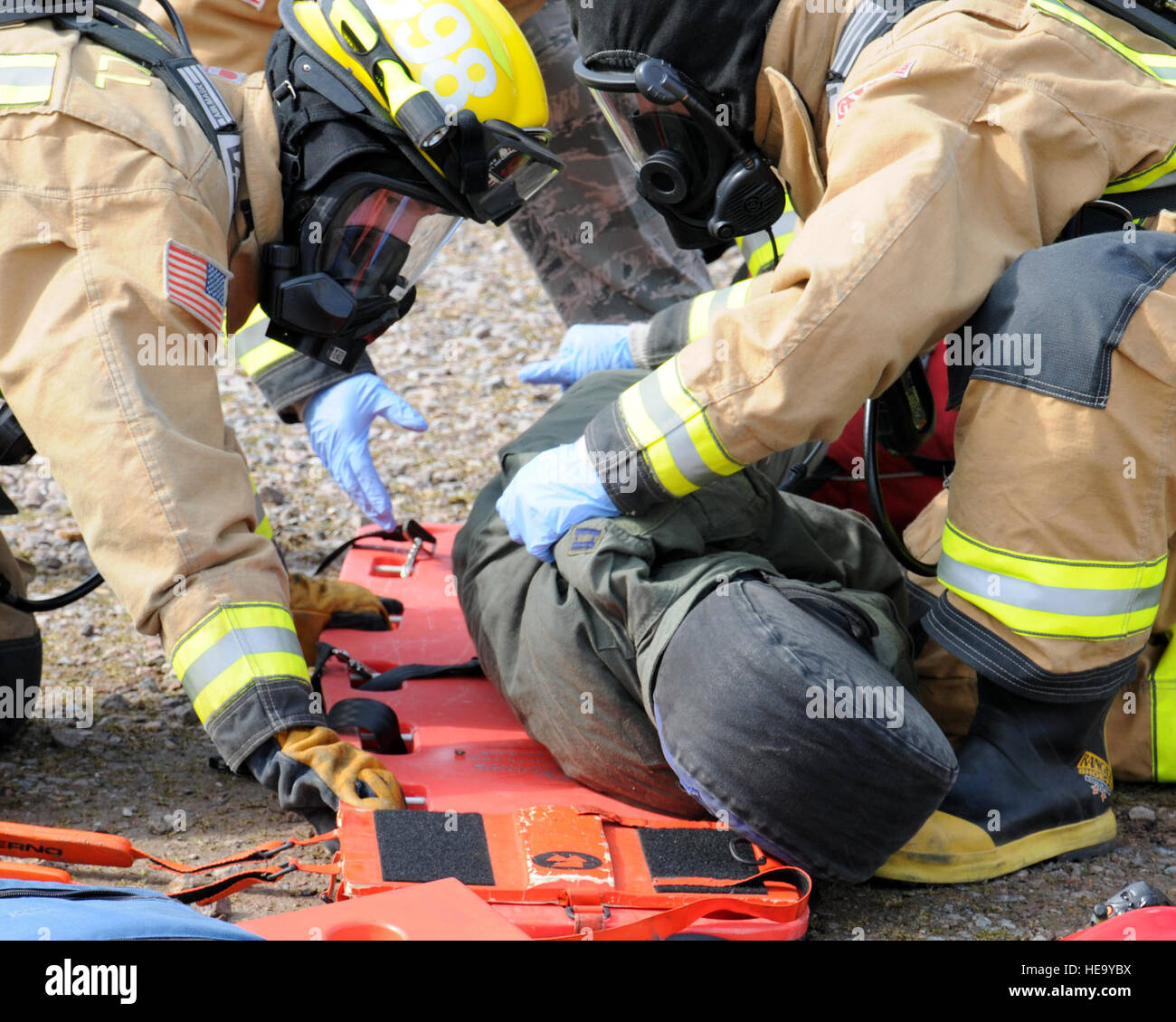 100e Escadron de génie civile Service d'incendie Les pompiers se préparent  à déplacer un patient simulé à une ambulance pour les soins médicaux au  cours d'un exercice le 25 mars 2013, à