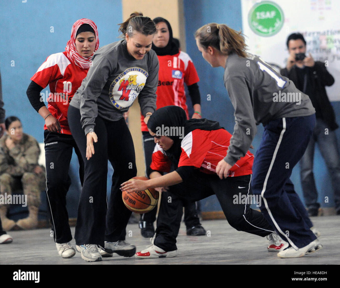 Les femmes afghanes un membre de l'équipe de basket-ball olympique récupère le ballon après un rebond au cours d'un match amical avec la Force internationale d'assistance et de l'équipe de l'ambassade des Etats-Unis au quartier général de la FIAS, le 7 mars. Le match a marqué la Journée internationale des femmes et reconnu le talent et le dévouement de l'Afghanistan nombre croissant d'athlètes féminines. Le s.. Kris Levasseur) Banque D'Images