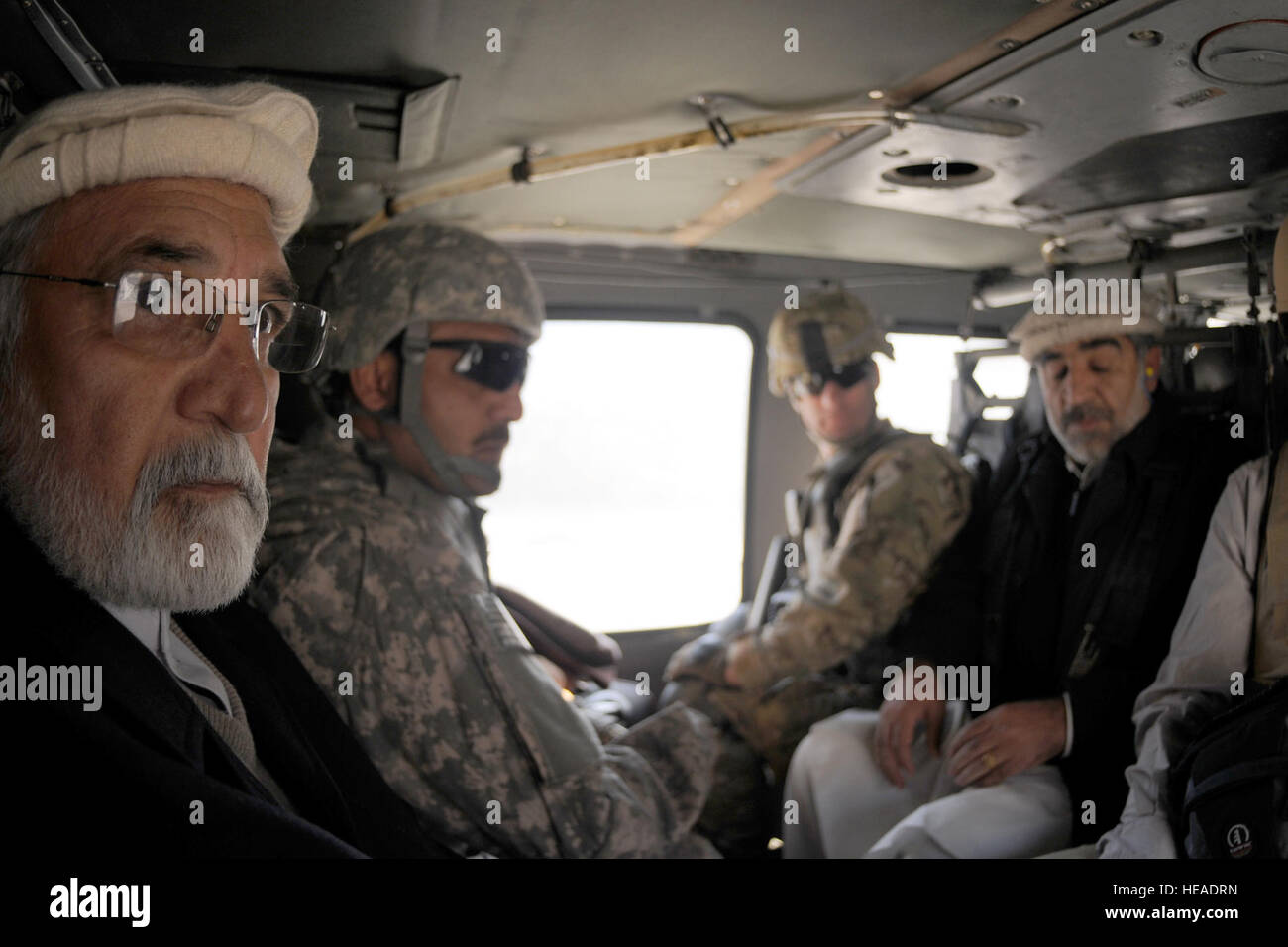 Fazlullah Wahidi, gouverneur de la province de Kunar, (gauche) et un interprète local de l'armée américaine, le Lieutenant-colonel Brian Pearl, 2e Bataillon, 12e Régiment d'infanterie, commandant, et Brigue. Khallullah le général Hussein, chef de la police de Kunar, trajet en l'armée américaine d'hélicoptères UH-60 Black Hawk de la Chapa Dara District centre à une base des Forces de la Coalition à proximité dans la vallée de la rivière Pech en Afghanistan, le 4 janvier. Le gouverneur de la province s'est rendu à la Chapa Dara, Manogai et Watapur sur un des districts de la princesse de deux jours pour rencontrer les sous-gouverneurs de district et l'administration en ligne, ainsi que les anciens du village et les membres de la choura à bette Banque D'Images