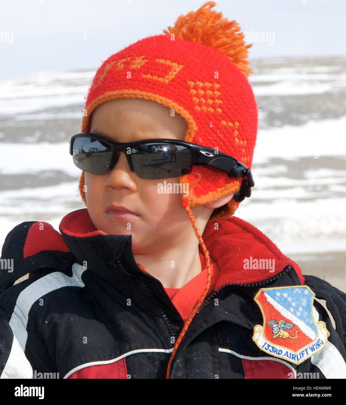 Un garçon regarde attentivement les Inuits locaux, portant un nouveau 133e Airlift Wing patch sur sa veste qui lui ont été données par le commandant de mission Lt .Col. Andrew Burda, 109e Escadron de transport aérien, comme le Minnesota Air National Guard C-130 Hercules cargo) décharge 'Moon-1' à Resolute, au Canada. Le C-130 est utilisé pour transporter la serre martienne, Lune-1 Humvee Rover 28 Mai, 2009. HMP prend en charge un programme d'exploration visant à développer de nouvelles technologies, les stratégies, les facteurs de l'expérience et savoir-faire opérationnel - la clé de la planification de l'avenir de l'exploration de la Lune et de Mars. La 'Moon-1" Banque D'Images