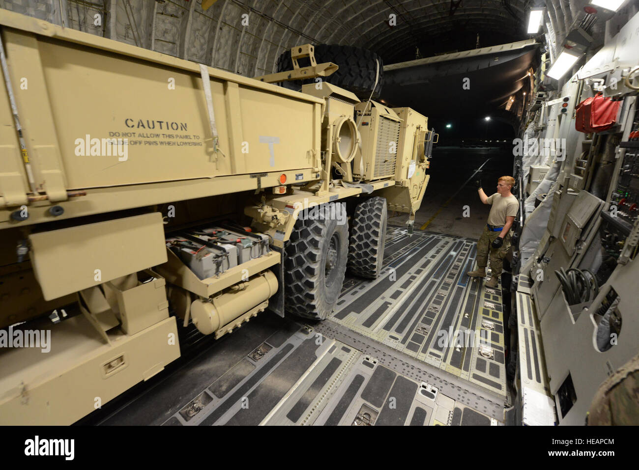 Les cadres supérieurs de l'US Air Force, un aviateur Nathaniel part processeur cargo affecté à la 455 e Escadron expéditionnaire Port Aérien guide le conducteur d'un camion de Mobilité élargi camion tactique à bord d'un C-17 Globemaster III, à l'air de Bagram, en Afghanistan, le 21 juin 2014. L'HEMTT est redéployé retour à la main aux Etats-Unis est originaire de Pueblo, Colorado, et déployés à partir du 62e Escadron, port aérien de la base aérienne McChord, dans l'état Master Sgt. Cohen A. Young Banque D'Images