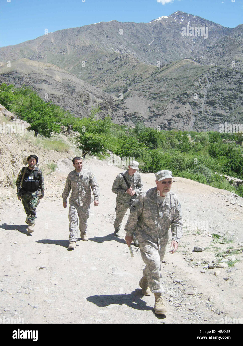 Scott Davis (avant) et 2e lieutenant Jason Adams (à l'arrière, droite) à pied avec un interprète local et garde dans la province du Panjshir moudjahidines, en Afghanistan. M. Davis est un représentant de la construction de l'Army Corps of Engineers joint à l'Équipe de reconstruction provinciale Panjshir. Le Lieutenant Adams est un PRT Panjshir ingénieur civil. Slt Jason Smith, PRT Panjshir Affaires publiques) Banque D'Images