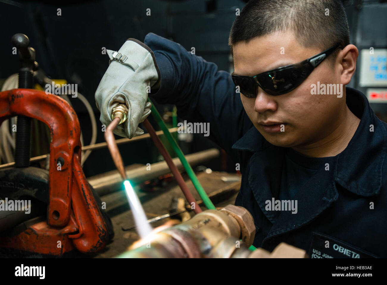 150707-N-XX566-031 Bremerton, dans l'état (7 juillet 2015) - Pompier Technicien de coque, Charliesean Obieta, de Los Angeles, chauffe le couplage sur un raccord pour aider à retirer est de la pipe à bord du USS JOHN C. STENNIS (CVN 74). Stennis se prépare actuellement à la Marine, l'inspection et de conseil (INSURV). Spécialiste de la communication de masse Andre 3e classe Richard T. Banque D'Images