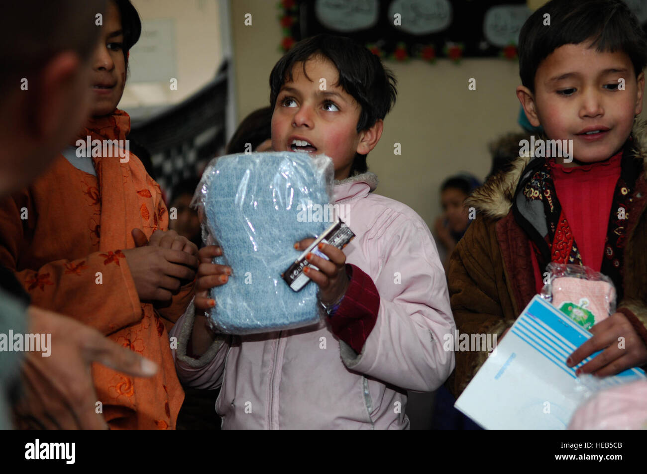 Une jeune fille afghane de l'Orphelinat Allauddin dit merci d'un foulard qu'elle a été donnée à Kaboul le 24 décembre. Un groupe de 12 conseillers de la 438th AEW/captf s'est rendu à l'orphelinat de Kaboul pour donner la 250 garçons et filles chaussures, gants, écharpes et chapeaux pour aider avec l'hiver froid. Banque D'Images