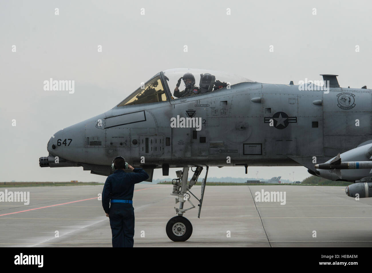 Un U.S. Air Force 354e Escadron expéditionnaire chef d'équipage salue le pilote d'un U.S. Air Force A-10 Thunderbolt II Aéronefs d'attaque au cours d'un déploiement de package de sécurité de théâtre à la base aérienne de Lask, Pologne, le 13 juillet 2015. L'aéronef déployés en Pologne dans le cadre de l'opération Atlantic résoudre pour renforcer les capacités de la puissance aérienne tout en soulignant l'engagement des États-Unis à la sécurité et la stabilité européennes. Le s.. Christopher Ruano Banque D'Images