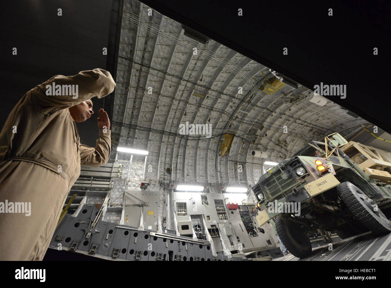 Le sergent de l'US Air Force. Orlando Infante, arrimeur affecté au 816th Escadron de transport aérien expéditionnaire, guides un camion relié à un système de détection des menaces persistantes d'amarrage Mobile remorque, qu'il soutient dans un C-17 Globemaster III le 26 août 2014 sur la ligne de vol de l'aérodrome de Bagram, en Afghanistan. Infante est originaire de Orlando, en Floride, et déployé de Charleston Air Force Base, L.C. (U.S. Air Force photo par le Sgt. Cohen A. Young/libérés) Banque D'Images