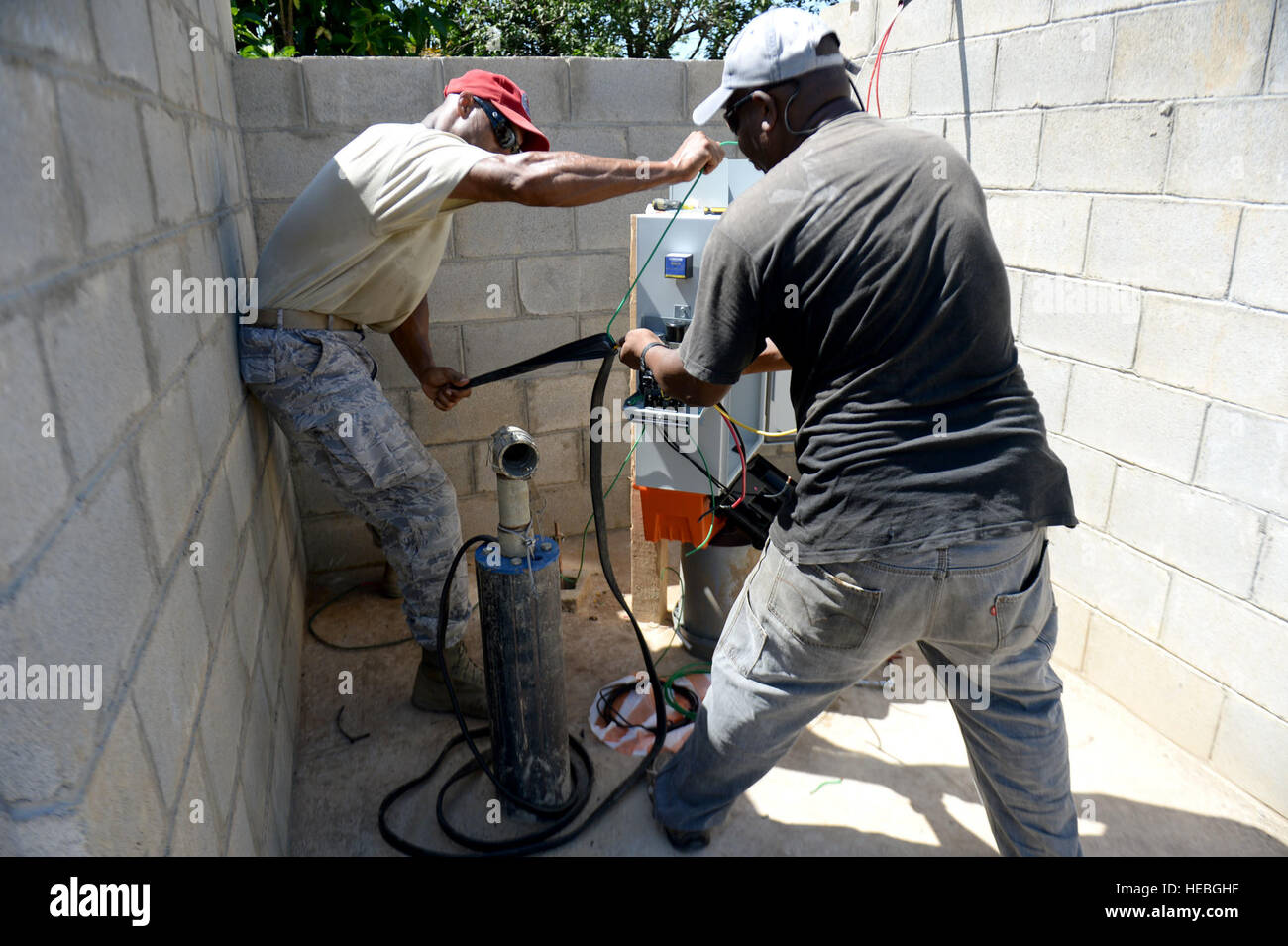 U.S. Air Force Tech. Le Sgt. Elton Vance (à gauche), 823e Escadron expéditionnaire Cheval Rouge artisan de forage de puits, hors de Hurlburt Field, en Floride, et Eric Ramos (extrême gauche), un électricien, travail à split un câble afin d'obtenir plus de mou dans le but d'installer un boîtier de commande d'alimentation sur le site du puits au Honduras Aguan, Honduras, 27 août 2015. L'Honduras grande marche bien a été l'un des deux a foré dans le cadre du programme Nouveaux Horizons Honduras 2015 Exercice d'entraînement. De nouveaux horizons a été lancé dans les années 80 et est un rapport conjoint sur l'exercice d'assistance humanitaire que U.S. Southern Command effectue avec un pays partenaire en 100 Banque D'Images