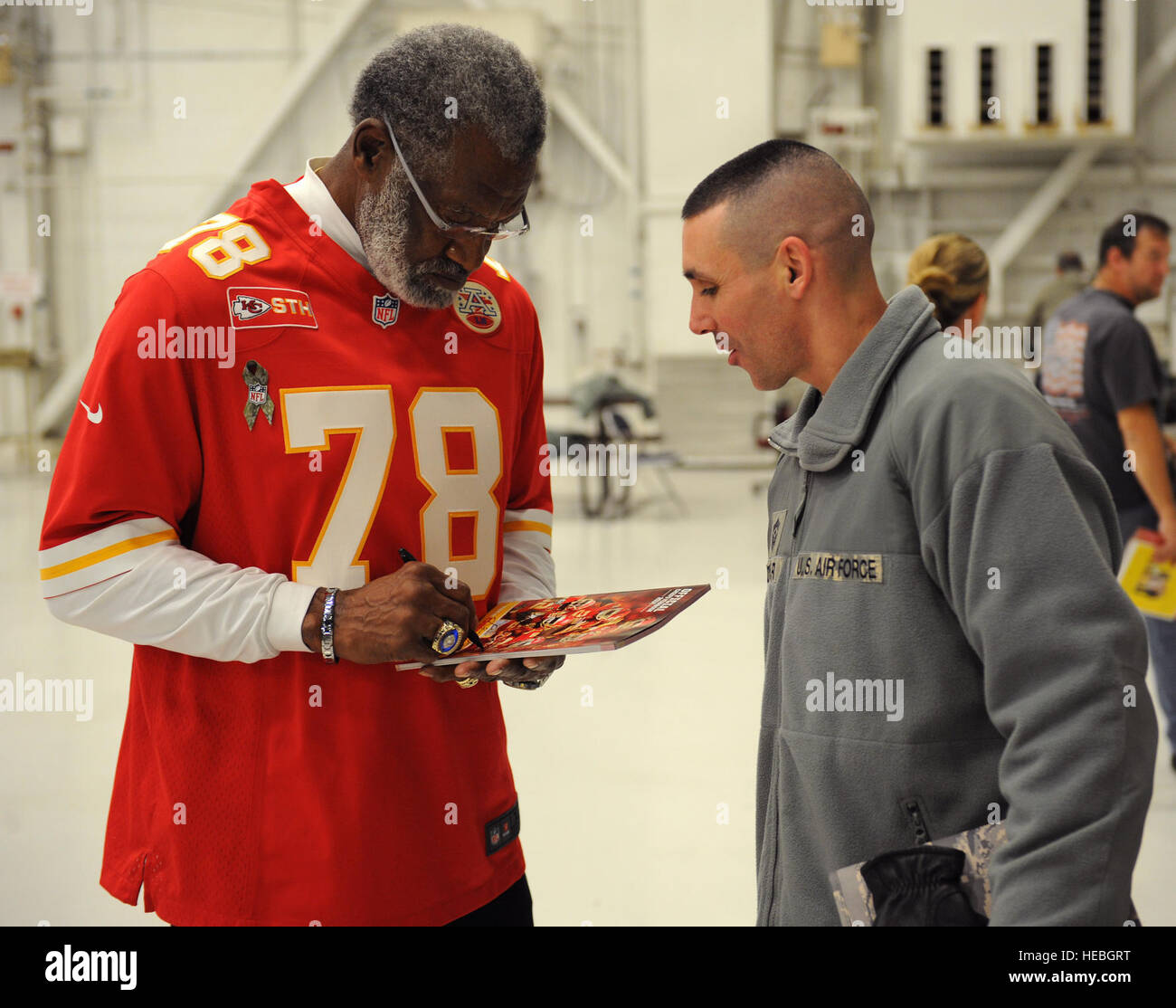 Kansas City Chiefs retraite défensive fin Bobby Bell signe une 2014 Kansas City Chiefs annuaire pour Master Chef Sgt. Shawn Drinkard, 509e Bomb Wing, commandement en chef à Whiteman Air Force Base, Mo., Novembre 18, 2014. Bell a été trois fois NFL Pro Bowl selectee durant sa carrière de footballeur professionnel. (U.S. Air Force photo par un membre de la 1re classe Joel Pfiester/libérés) Banque D'Images