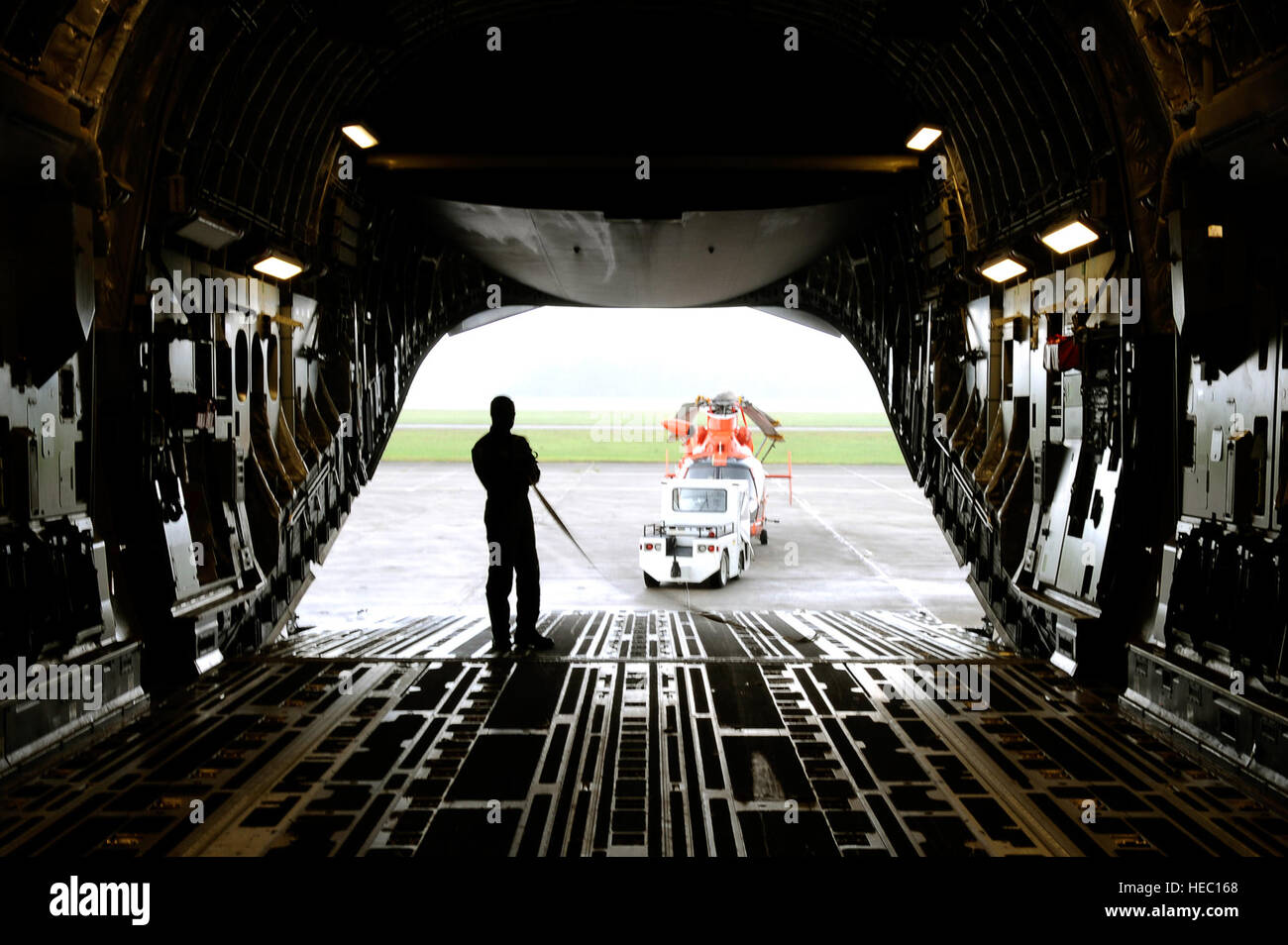 Le sergent-chef de l'US Air Force. Robert Barrett, arrimeur avec le 300e Escadron de transport aérien, permet de déchargement d'un MH-65C hélicoptère Dauphin, affecté à la Garde côtière des États-Unis, à partir d'un C-17 Globemaster III sur la base aérienne de Charleston, S.C., le 4 juillet 2010. Aviateurs mènent contre la drogue et la formation des équipages de missions au cours de cinq jours d'affectations temporaires à El Salvador, Panama, Porto Rico et les États-Unis. (U.S. Air Force photo de Tech. Le Sgt. Dennis J. Henry Jr./libérés) Banque D'Images