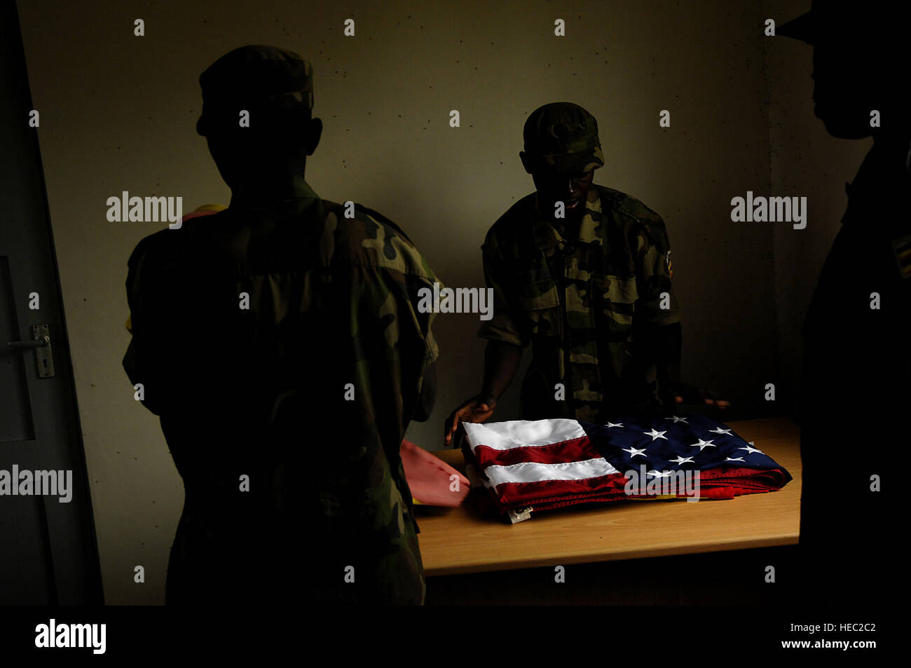 Les soldats de l'Armée de l'Ouganda après les drapeaux pli vers le bas à partir de la base d'un drapeau polonais quand la pluie a commencé le 14 février 2008 à l'emplacement avancé d'opérations Kasenyi, en Ouganda. Les soldats du 3e Peloton de la compagnie Delta, 1er Bataillon, 3e Régiment d'infanterie, la vieille garde, Fort Myers, Florida sont chargés de former les soldats ougandais pendant une semaine 16 à l'école de formation militaire militaire situé à l'emplacement avancé d'opérations Kasenyi, en Ouganda. (U.S. Air Force photo de Tech. Le Sgt. Jeremy T. Lock) (Sortie) Banque D'Images