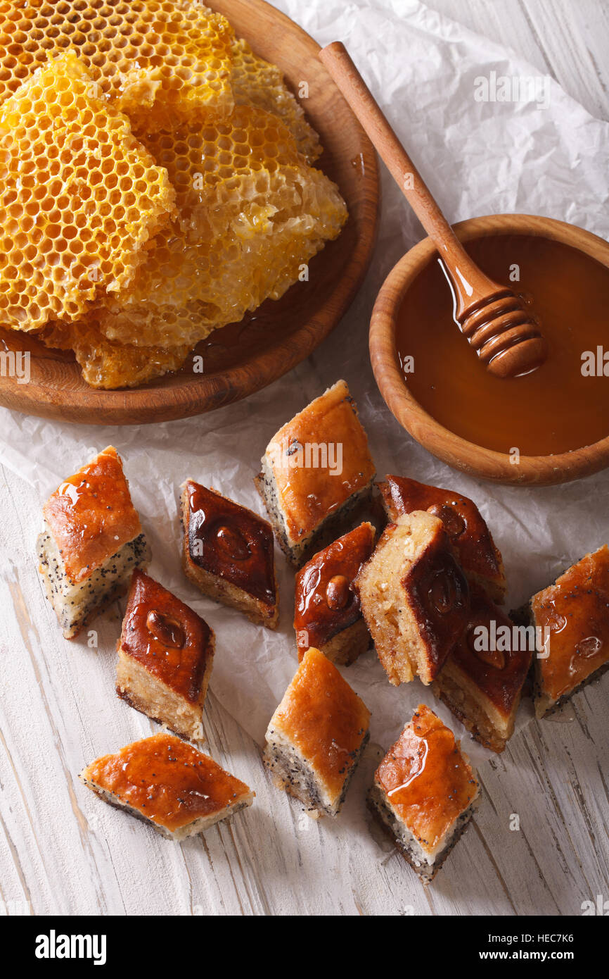 Douceurs orientales : baklava aux graines de pavot et les écrous sur une table, et un rayon de miel. La verticale Banque D'Images