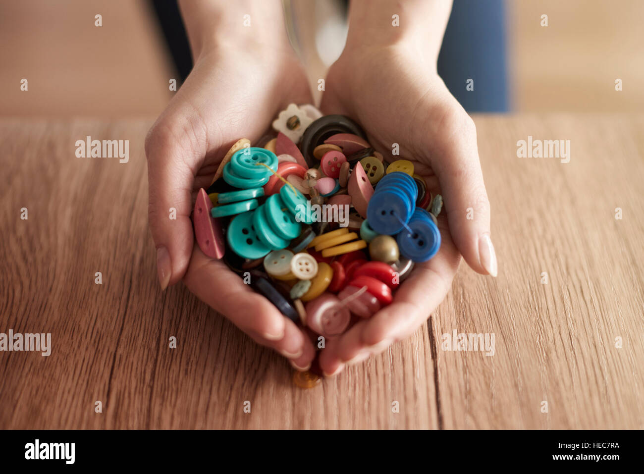 Les mains pleines de boutons colorés Banque D'Images
