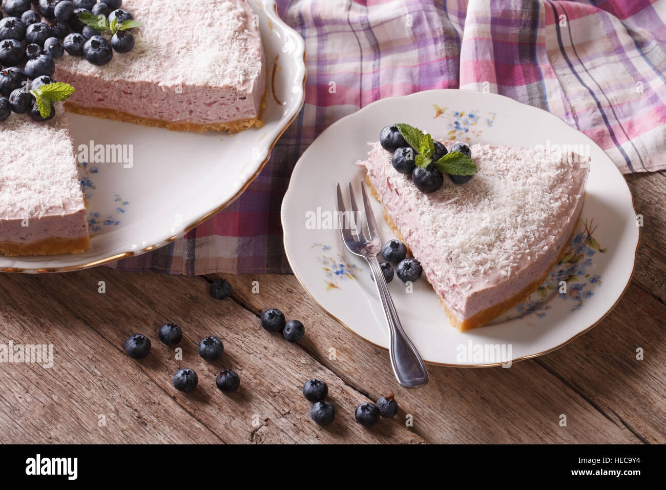 Tranches de gâteau aux bleuets avec les baies fraîches et de noix de coco sur la table horizontale. Banque D'Images