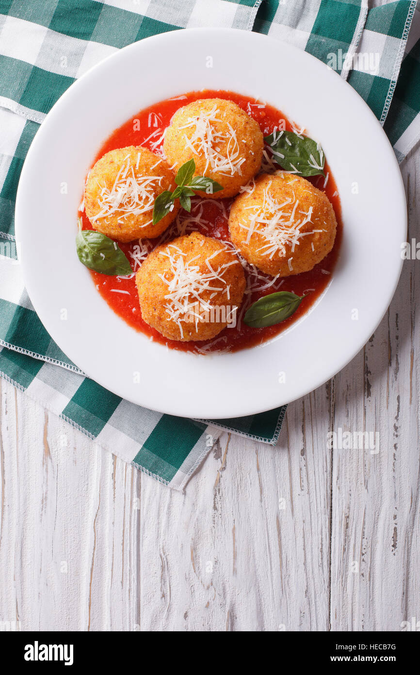 Arancini frits boulettes de riz avec de la sauce tomate sur la table verticale Vue de dessus. Banque D'Images