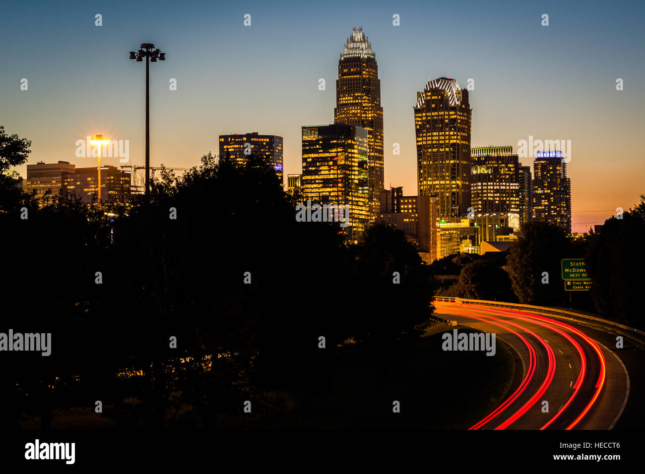 Une longue exposition de la circulation sur l'autoroute de l'Andrew Jackson et d'afficher de l'Uptown Charlotte skyline at night, du pont de l'Avenue centrale, à Charlotte Banque D'Images