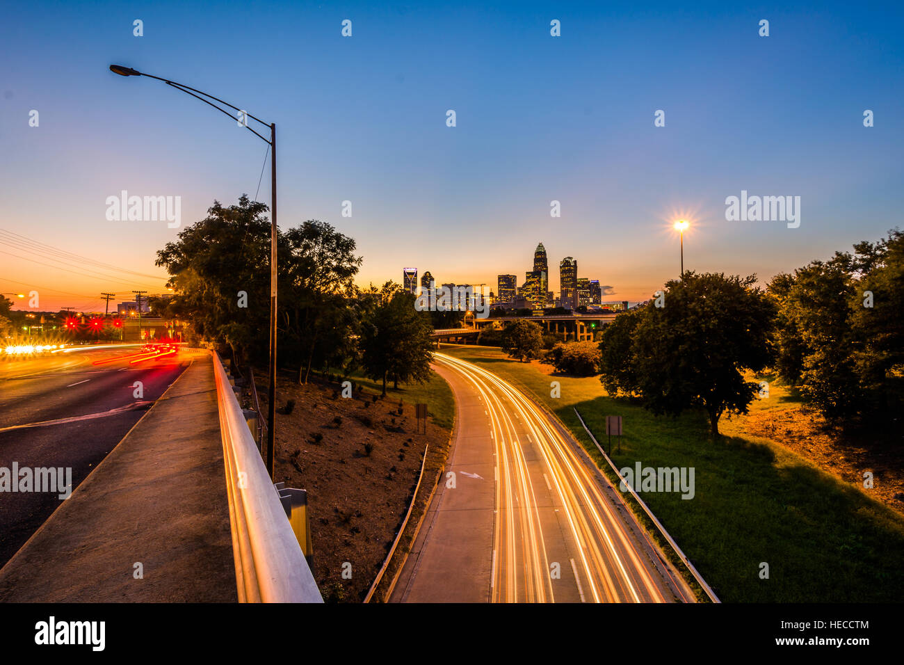 Une longue exposition de la circulation sur l'autoroute de l'Andrew Jackson et d'afficher de l'Uptown Charlotte skyline at night, du pont de l'Avenue centrale, à Charlotte Banque D'Images