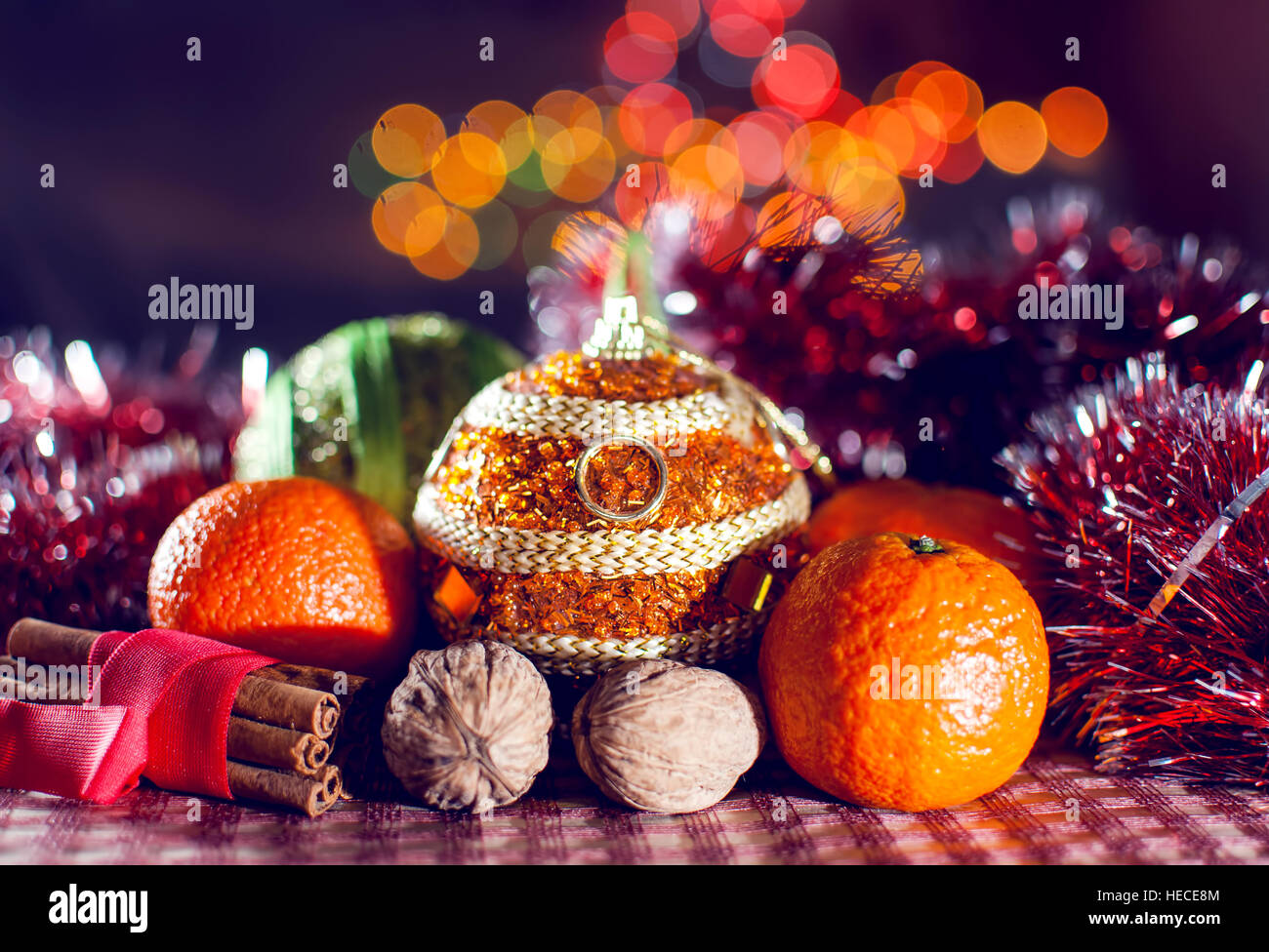 Image de décoration du Nouvel An, des boules de Noël, la cannelle, les mandarines, les noix sur le contexte des lumières bokeh. Clé faible. Focus sélectif. Banque D'Images
