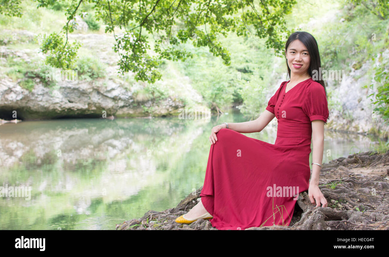 Mode femme assis près d'une rivière seul Banque D'Images