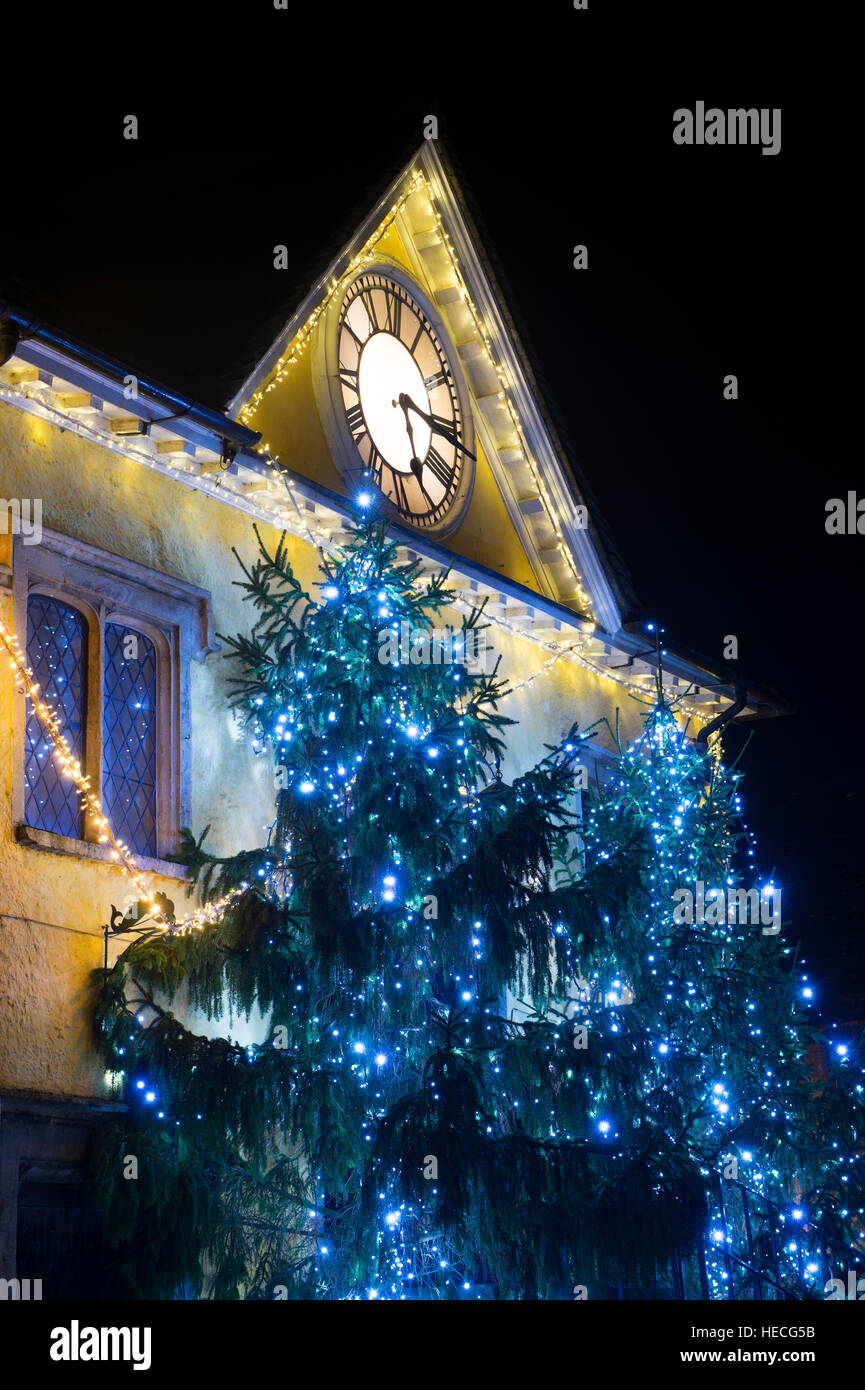 Les arbres de Noël et les lumières autour de la maison pendant la nuit. Tetbury Gloucestershire, Angleterre Banque D'Images