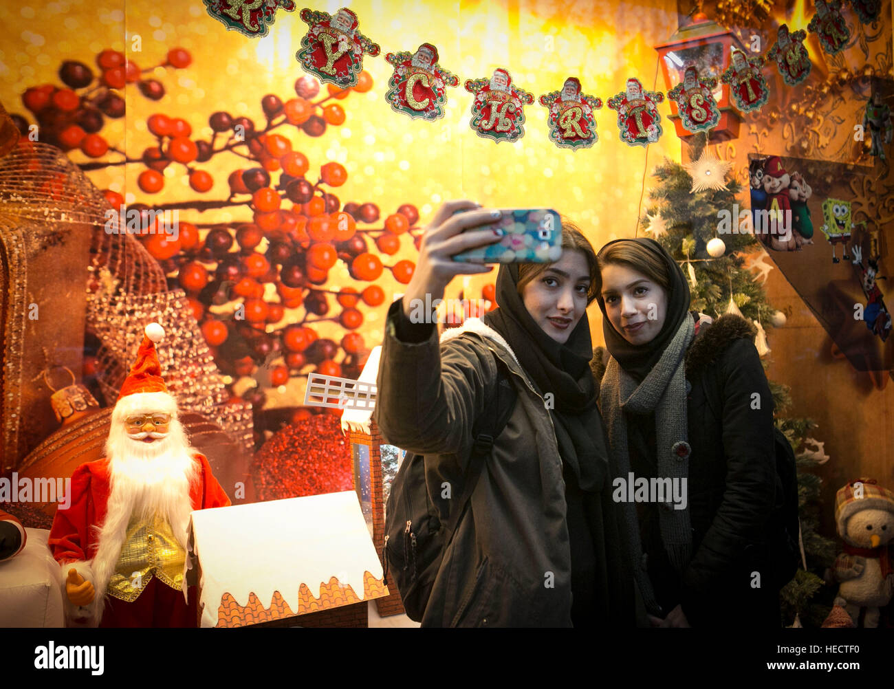 Téhéran, Iran. Dec 19, 2016. Les femmes iraniennes prendre vos autoportraits en l'état à côté des décorations de Noël dans une rue de Téhéran, capitale de l'Iran, au 19 décembre 2016. © Ahmad Halabisaz/Xinhua/Alamy Live News Banque D'Images