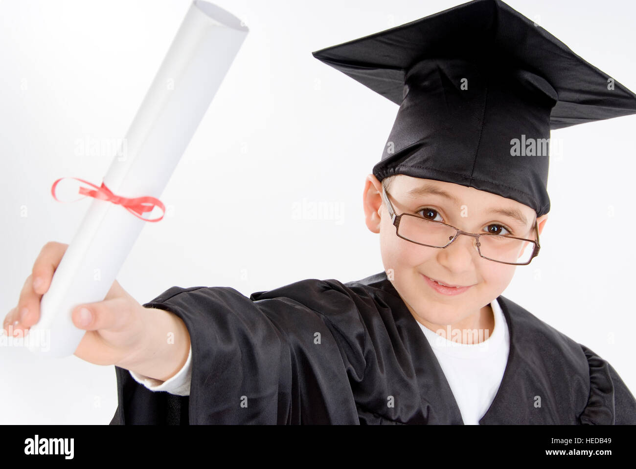 7 ans habillé comme diplômé, cap and gown, holding diploma Banque D'Images