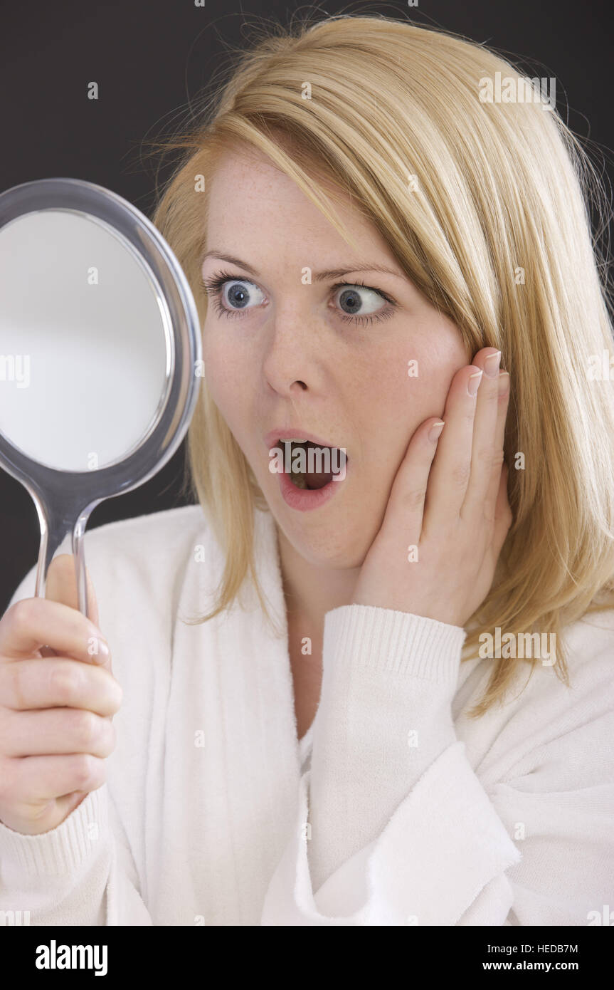 Femme à la recherche dans le miroir, expression choquée Photo Stock - Alamy