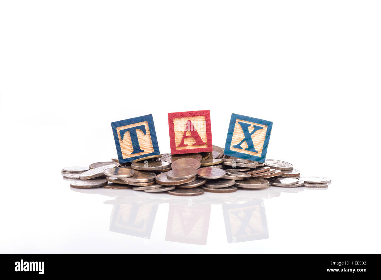 Pile de pièces de monnaie Thaï et "taxe" écrire en bois coloré alphabet blocks isolé sur fond blanc Banque D'Images