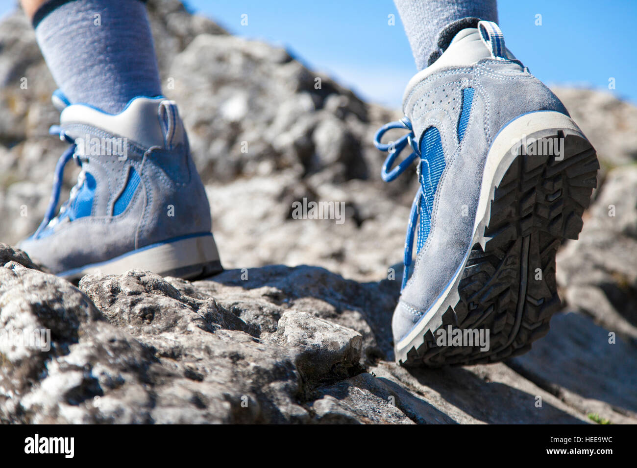 Close up de bottes de randonnée et escalade jambes jusqu'sentier rocheux et d'atteindre le sommet d'une montagne Banque D'Images