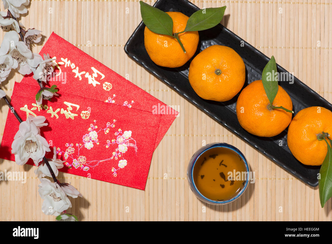 Mandarines et nouvel an lunaire avec texte 'Bonne Année' sur poche rouge. Concept du Têt. Banque D'Images
