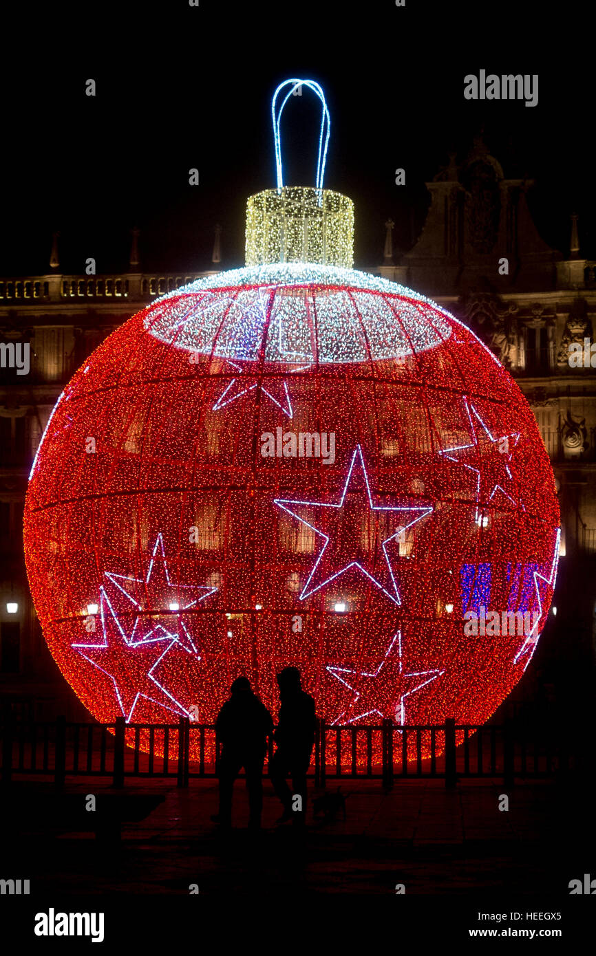 Deux silhouettes sur une bille de verre de Noël géant mobile pendant la période des fêtes. Salamanque Banque D'Images