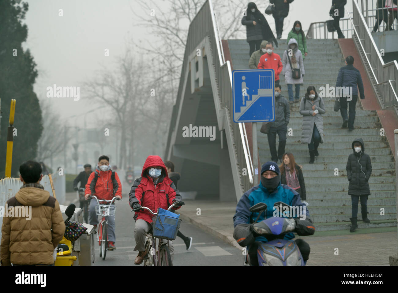 Les résidents avec des masques en attente de l'autobus comme le questions de Beijing l'alerte rouge pour le smog à Pékin, en Chine. 20-Déc-2016 Banque D'Images