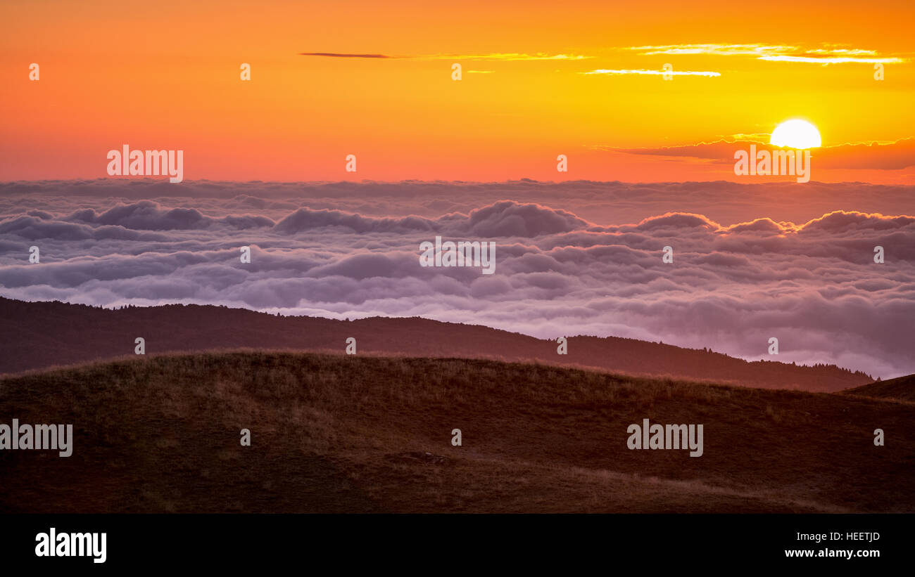 Le lever du soleil sur la plaine vénitienne, avec vague de nuages. Vue depuis la montagne, plateau Cansiglio Prealpi Venete. Veneto. L'Italie. L'Europe. Banque D'Images