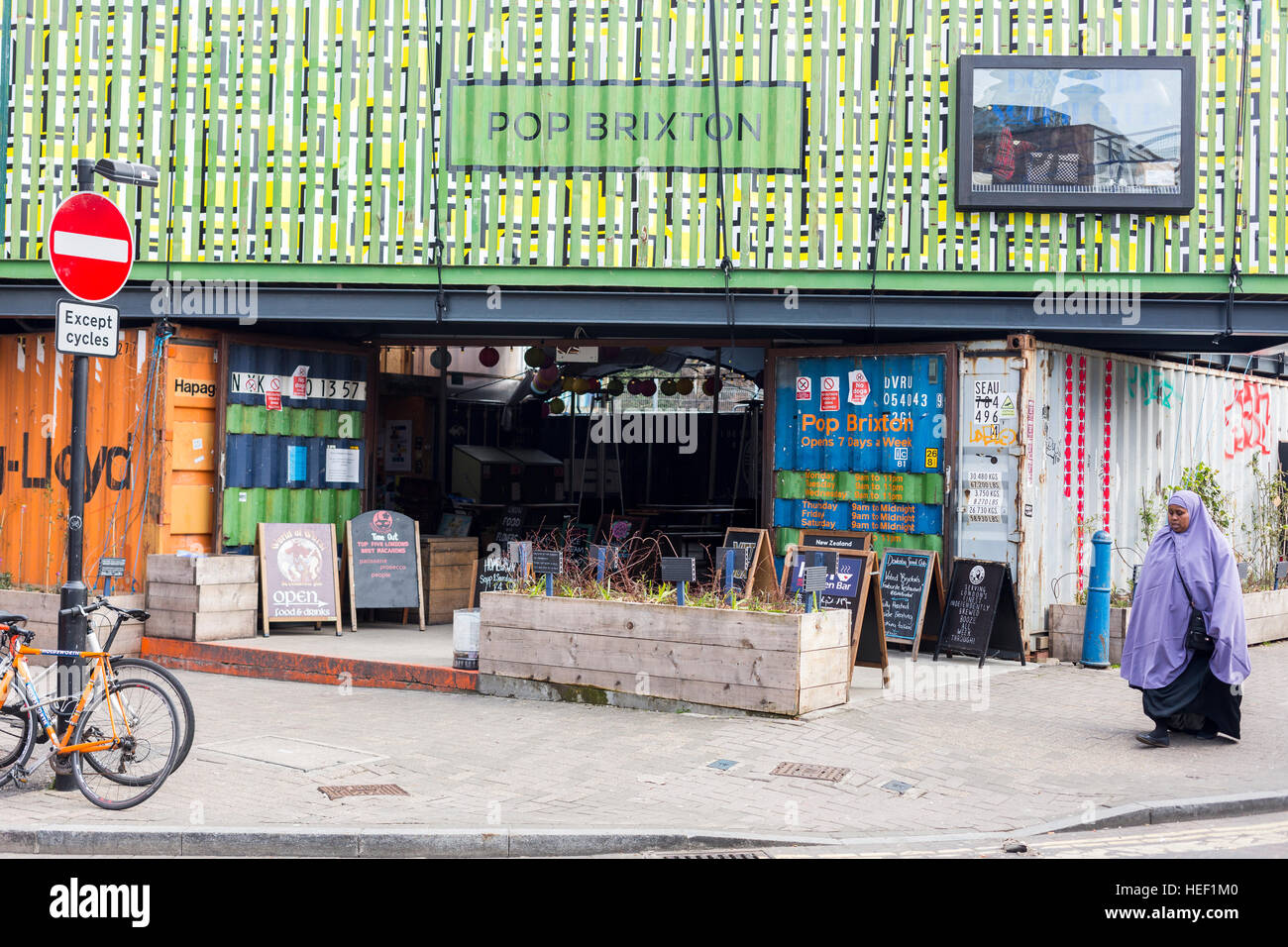 Une fenêtre pop-up market à Brixton avec une femme musulmane en passant devant, Londres Banque D'Images