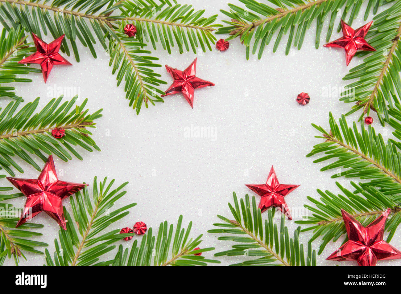 Des branches de sapins et décorations de Noël en forme d'étoile sur fond pétillant Banque D'Images