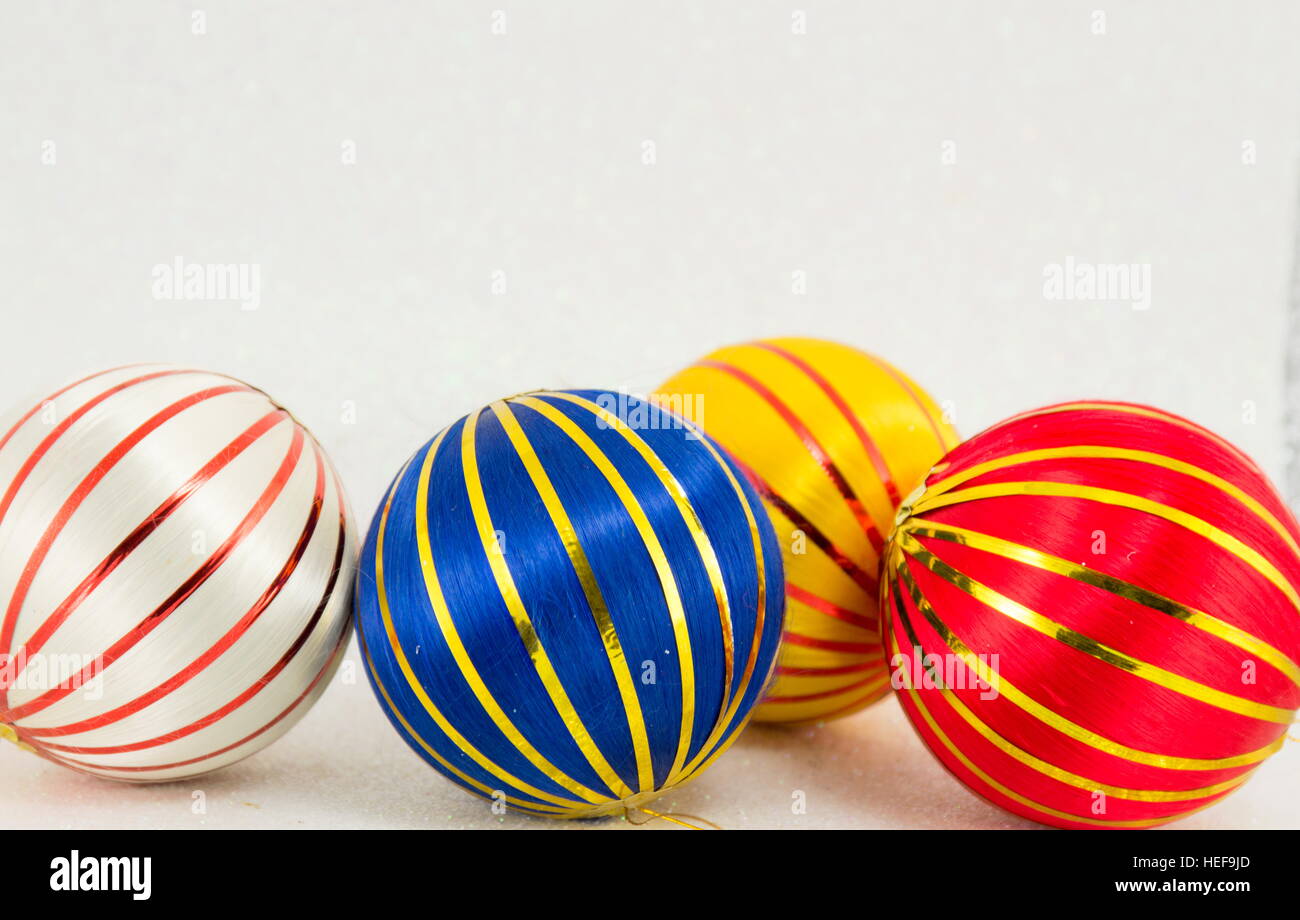 Trois boules de Noël colorées avec des lignes d'or sur fond blanc Banque D'Images