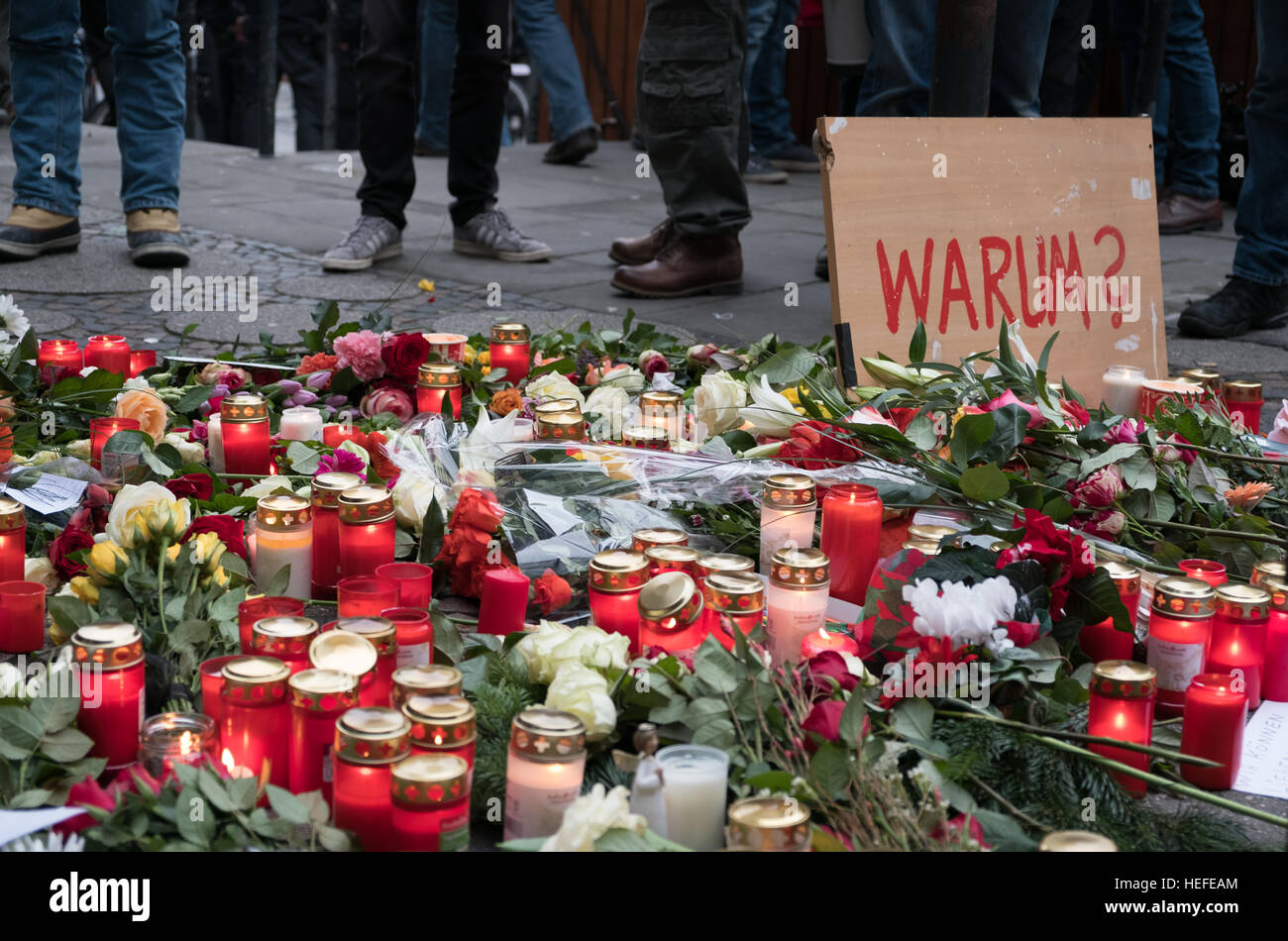Les bougies, les fleurs et un signe avec le mot allemand 'Warum' (pourquoi) au marché de Noël à Berlin, le jour après l'attaque terroriste Banque D'Images