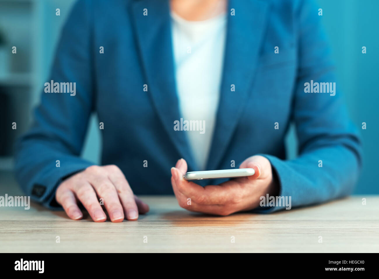 Businesswoman using smartphone, femmes en costume bleu élégant holding mobile phone, selective focus Banque D'Images