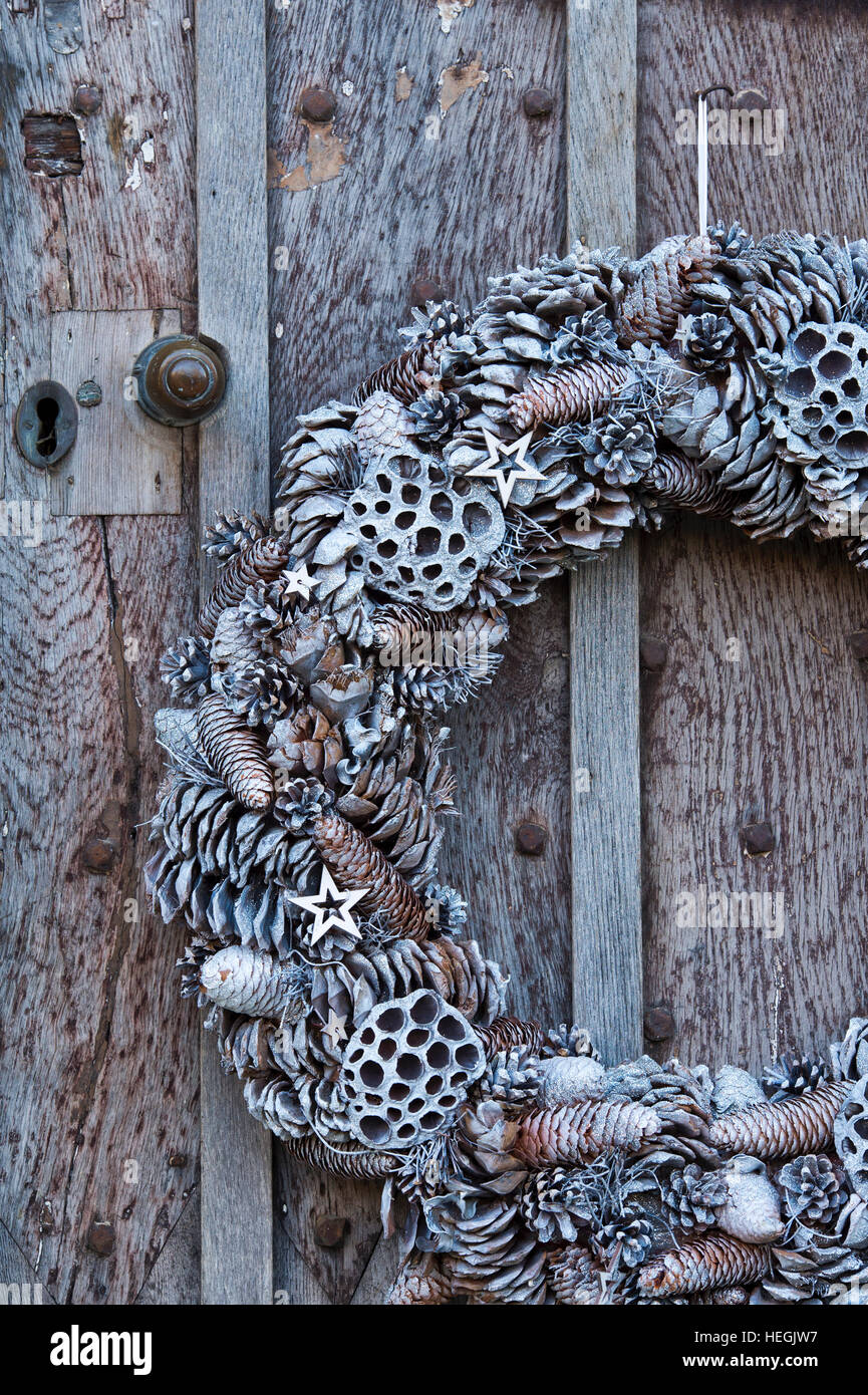 Noël blanc couronne conique sur la vieille porte en bois cloutée en chêne. Stanton, Arles, France Banque D'Images