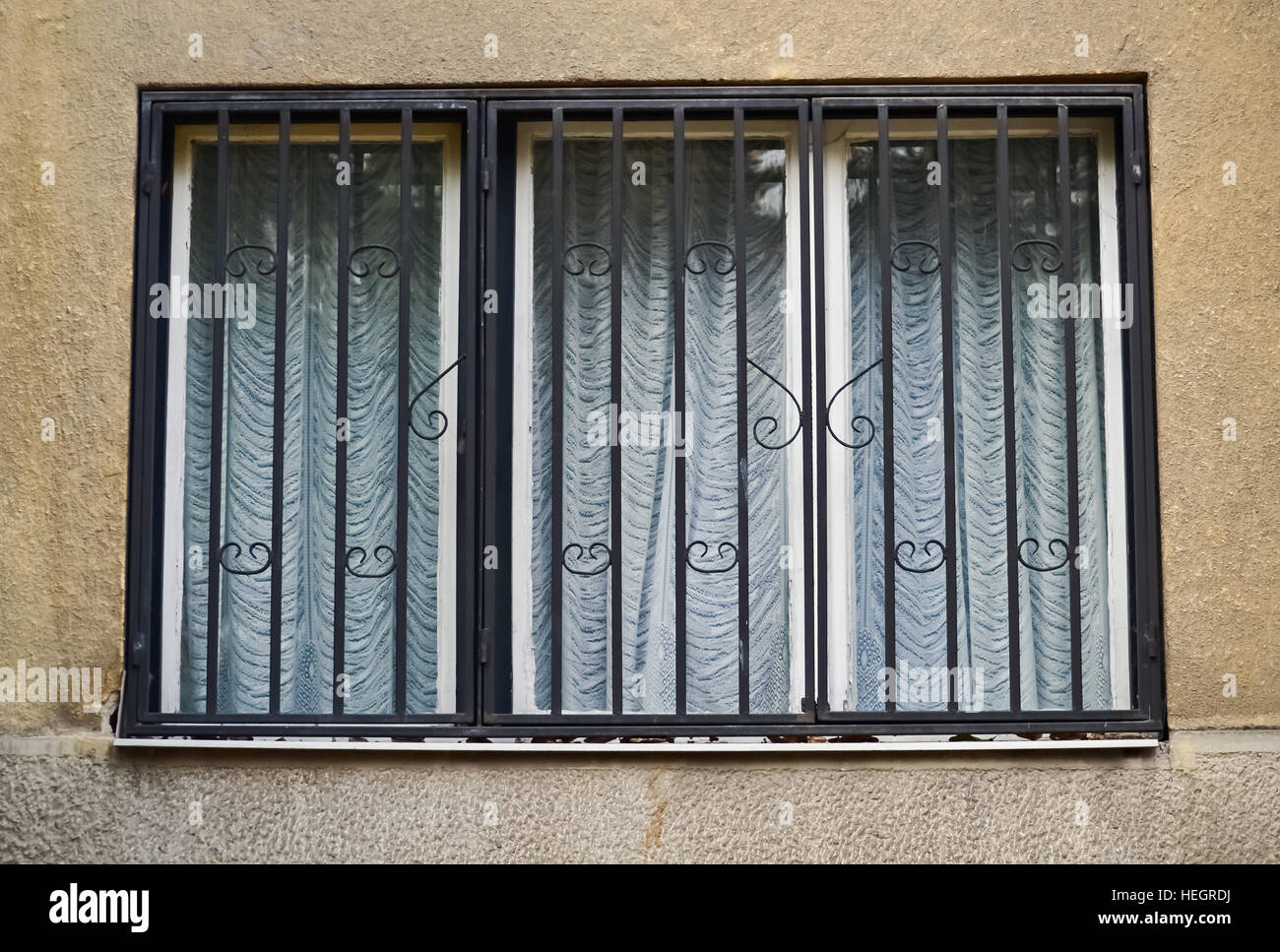 Libre d'une ancienne fenêtre avec des barres de métal et le rideau Banque D'Images Libre d'une ancienne fenêtre avec des barres de métal et le rideau Banque D'Images