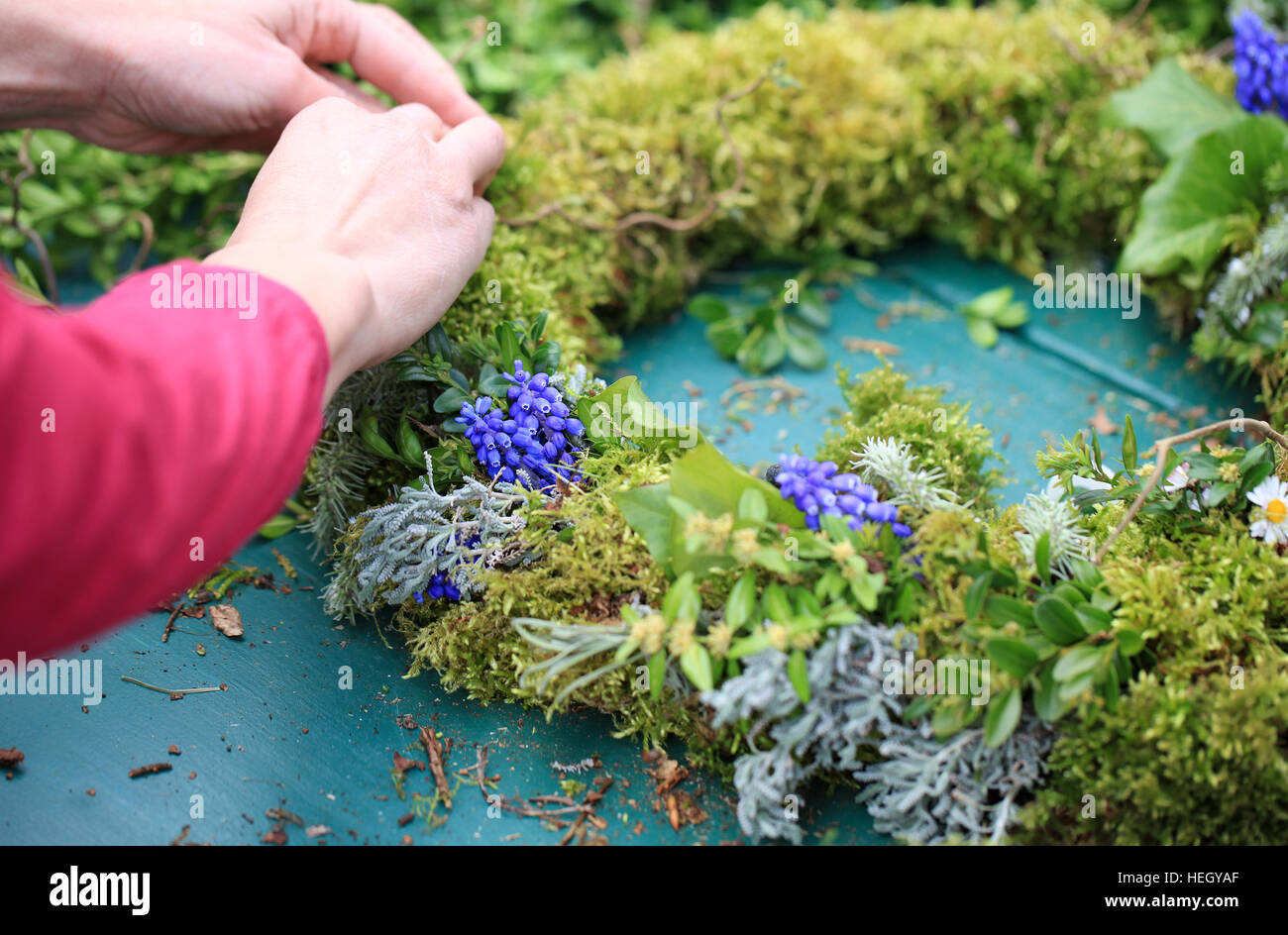 Mains d'une femme porte une couronne de printemps Banque D'Images