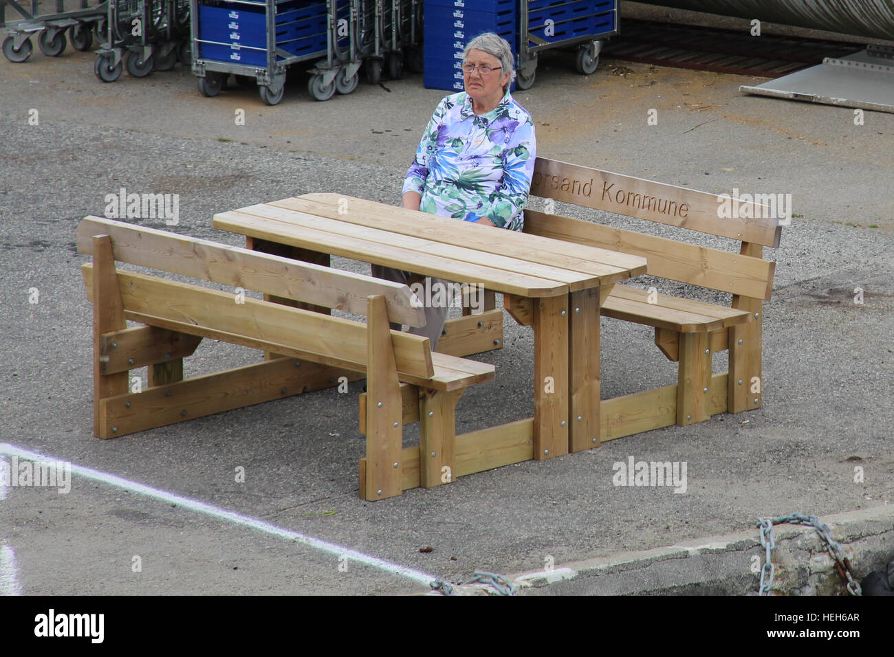 Un seul, au sérieux, à la vieille dame assise sur un banc en bois Banque D'Images