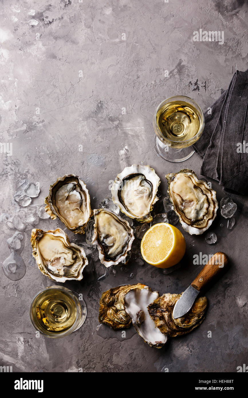Ouvert les huîtres de Claire des amendes et le vin blanc sur le béton gris texture background copy space Banque D'Images Ouvert les huîtres de Claire des amendes et le vin blanc sur le béton gris texture background copy space Banque D'Images