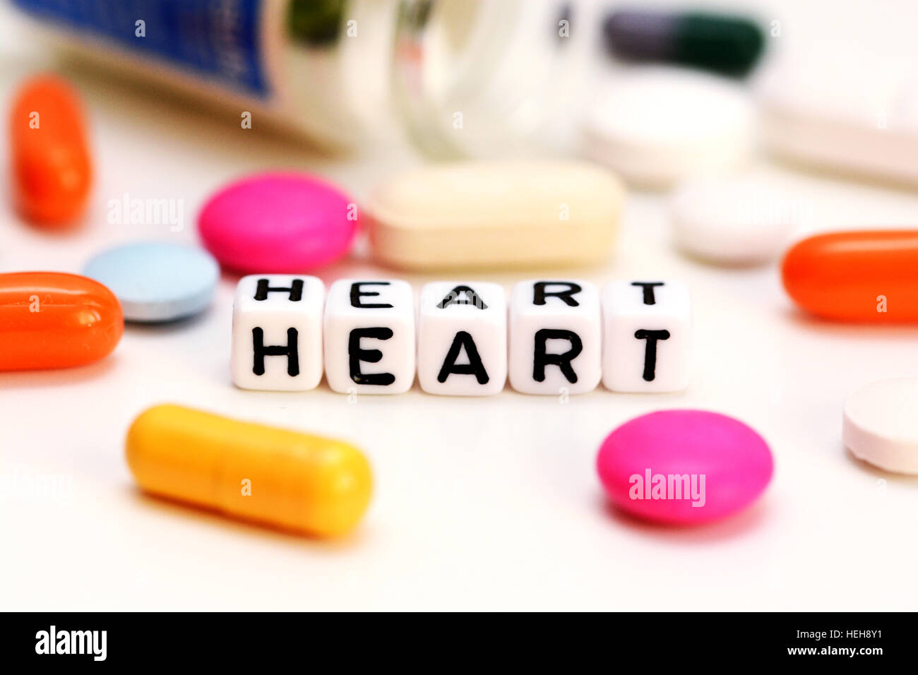 Médicaments et multicolore lettres orthographe coeur, suggérant des problèmes cardiaques Banque D'Images
