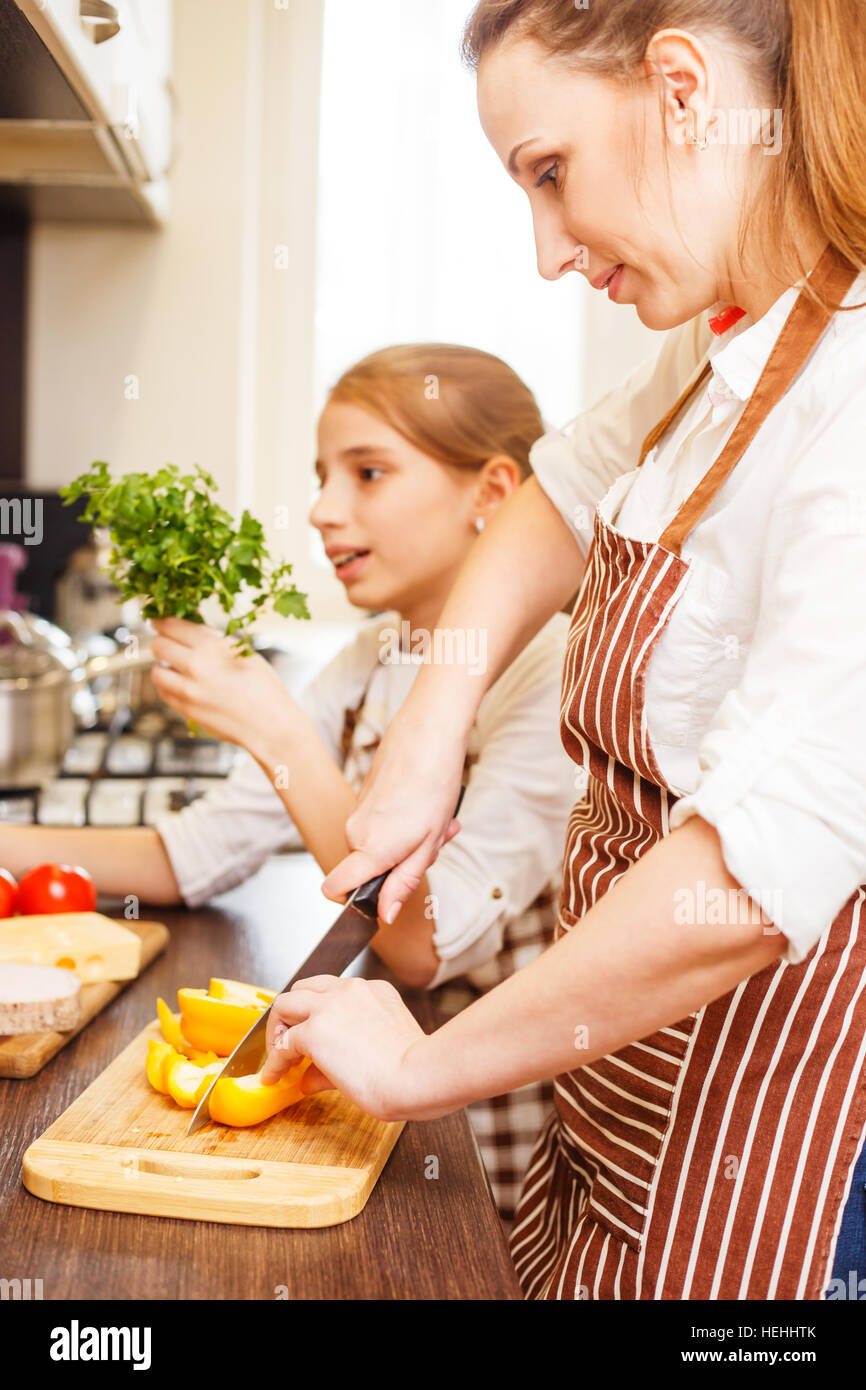 Jeune femme et sa fille cuisiner ensemble dans la cuisine. Adolescente avec sa mère s'amusant à la cuisine familiale Banque D'Images