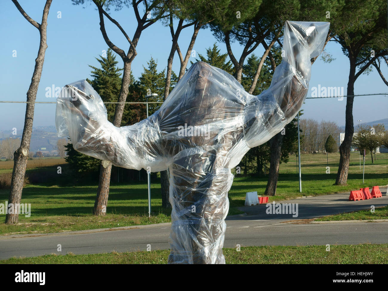 Une statue de bronze est recouverte de feuilles de plastique à l'extérieur de l'aéroport de Pérouse Banque D'Images