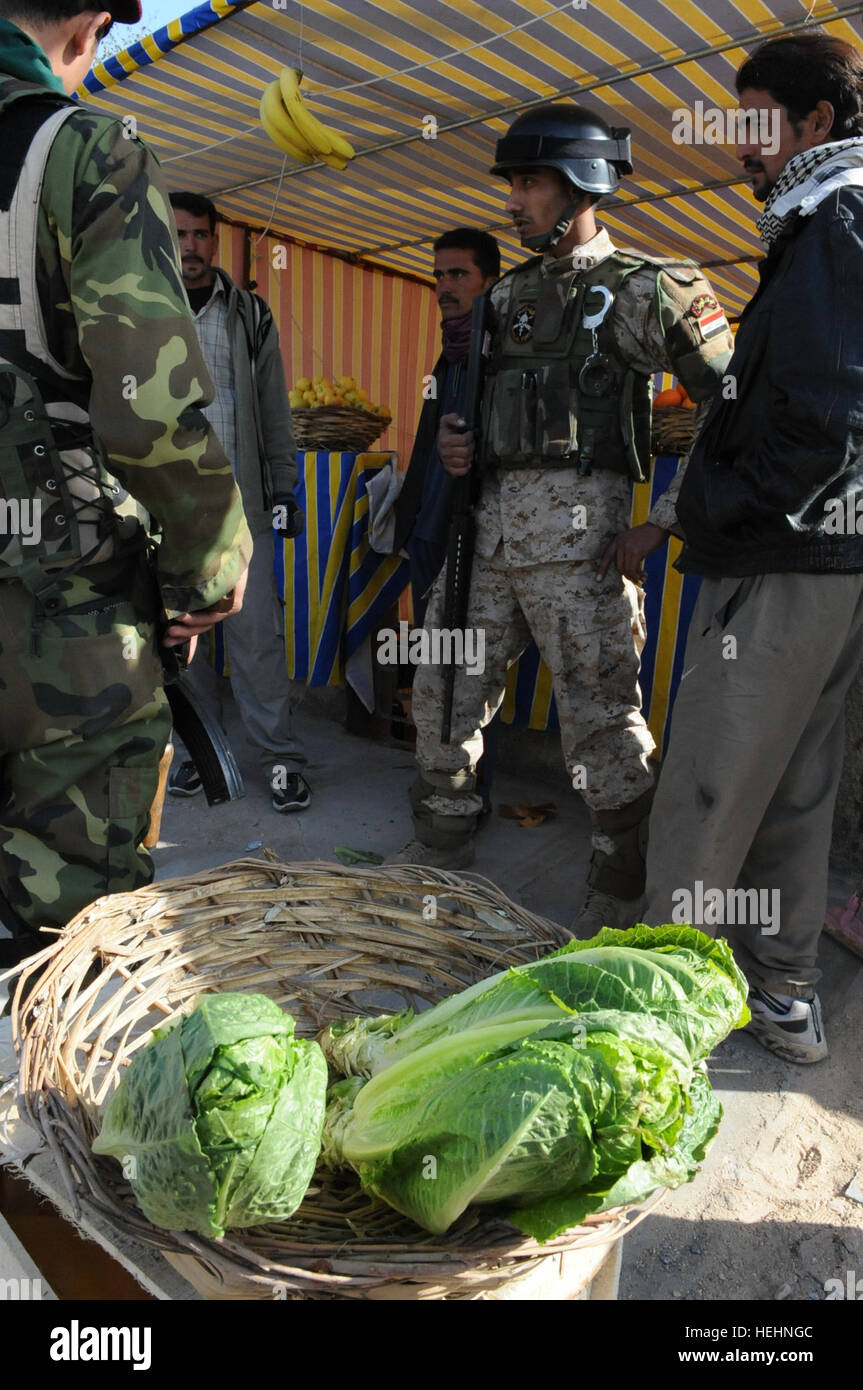 Des soldats iraquiens parler avec les propriétaires d'un stand de fruits et légumes au cours d'une patrouille à pied avec des soldats américains de B, 5e Troupe de Cavalerie, 73e Régiment, 3e Brigade Combat Team, 82e Division aéroportée, dans, Muhallah 710, Muthana Zayuna, l'est de Bagdad, l'Iraq, le 2 janvier 2009. Patrouille conjointe dans l'Est de Bagdad 142107 Banque D'Images