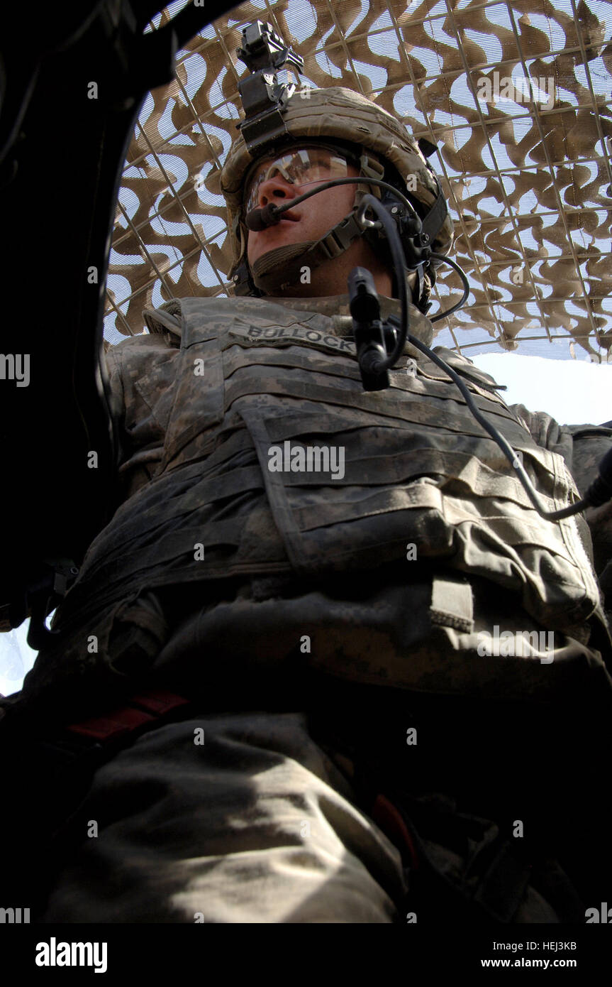 La CPS de l'armée américaine. John Bullock, affecté à la Compagnie Charlie, 1er Bataillon, 5e régiment de cavalerie, 2e Brigade, 1e Division de cavalerie, des montres pour l'activité de la tourelle d'artilleurs un MRAP (mine, résistant à une embuscade véhicule protégé) sur la façon de Sheik Hamad Village près de Tarmiyah, l'Iraq, le 16 septembre 2009. L'opération consiste à donner des purificateurs d'eau pour les gens de la communauté. Livraisons 205552 purificateur d'eau Banque D'Images