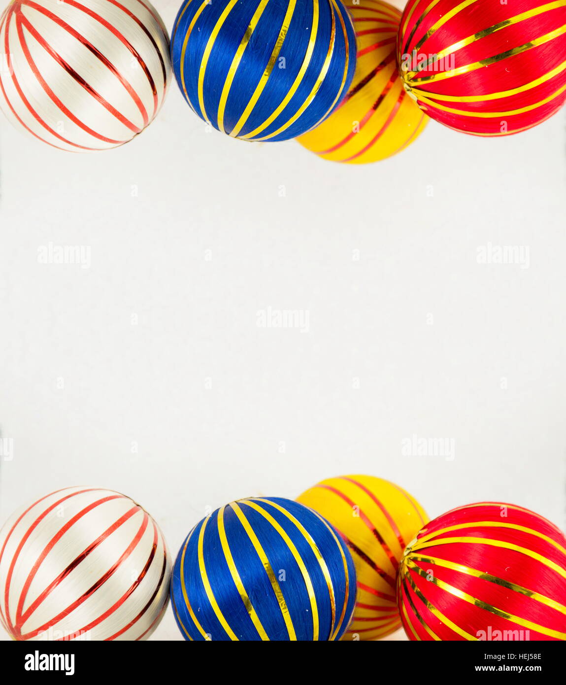 Trois boules de Noël colorées avec des lignes d'or sur fond blanc Banque D'Images